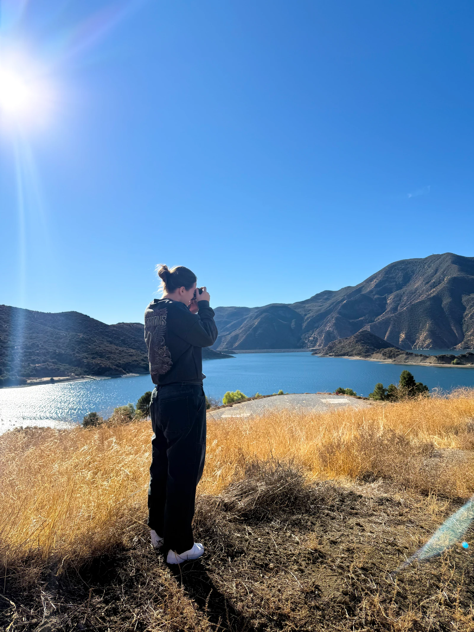 Daria Zamorskaia photographing outdoors beside a lake and mountains